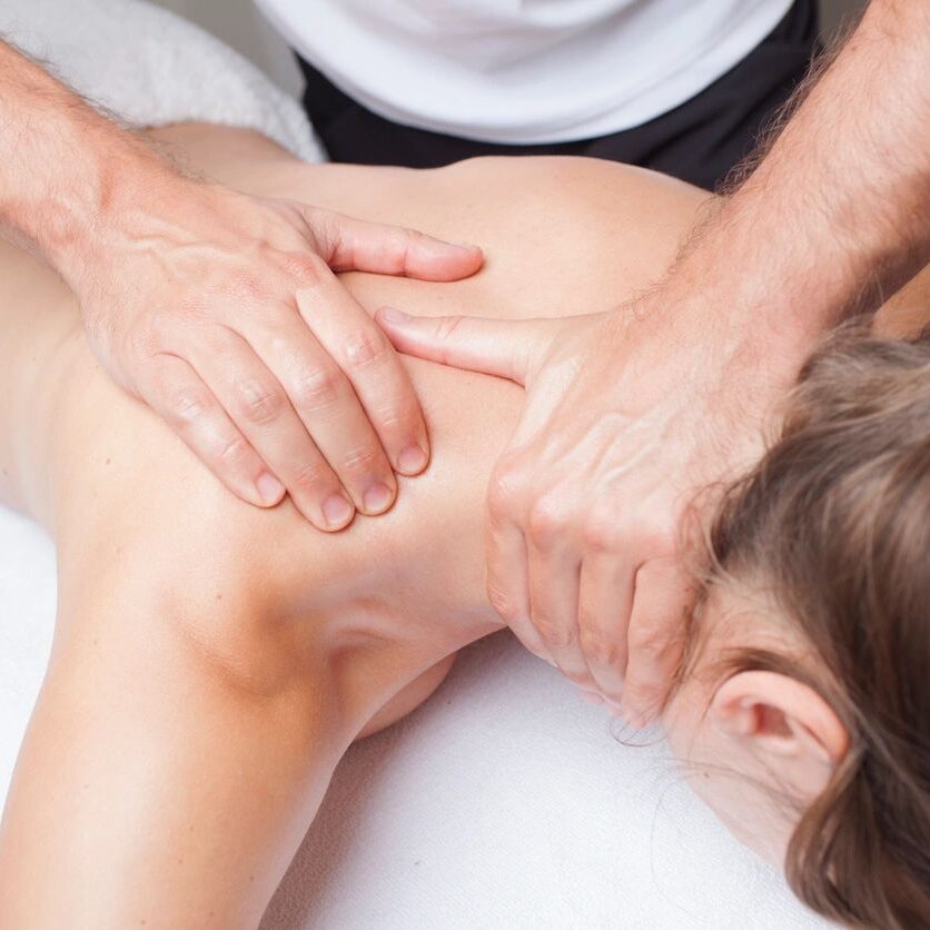 A person is getting their back examined by an osteopath.